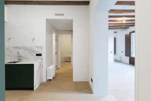 Imagen interior de la zona de cocina y salón de Casa Malla en Rambla 29, una vivienda de lujo en el centro de Barcelona.